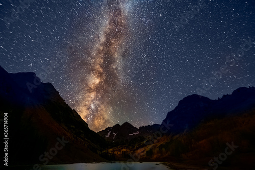 Maroon Bells peak lake wide angle view of dark night milky way sky in Aspen, Colorado with rocky mountain in October 2019 autumn