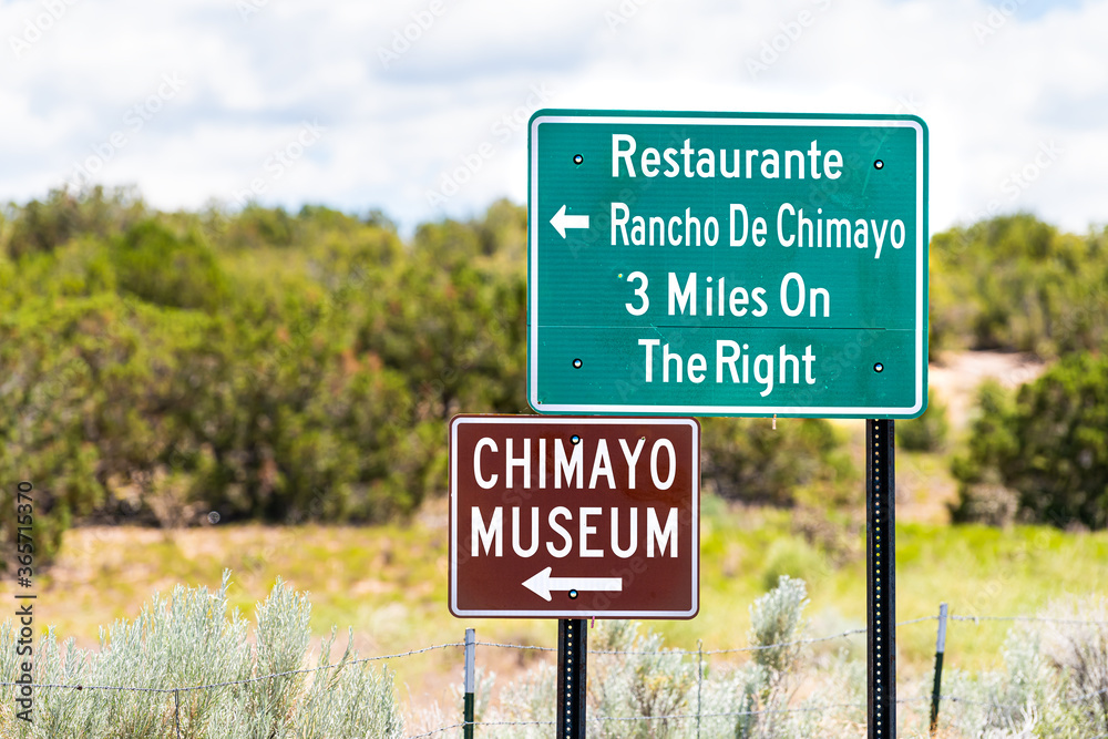 Fototapeta premium Scenic drive during summer at High Road to Taos famous trip near Santa Fe with direction signs for Chimayo town village museum and restaurants in New Mexico