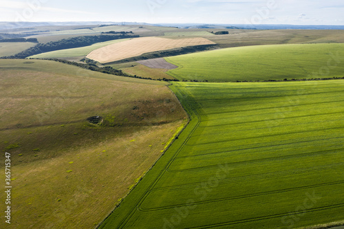 Stunning high flying drone landscape image of rolling hills in English countryside with lovely warm late evening light