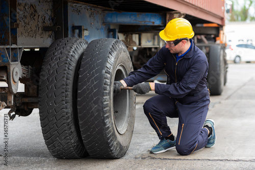Technical engineer checking tire of a truck.