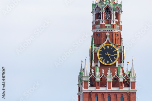 View of Spasskaya Tower and red brick wall of Moscow Kremlin on a summer day. Clouds on the sky in the background. Copy space for your text. Theme of travel in Russia.
