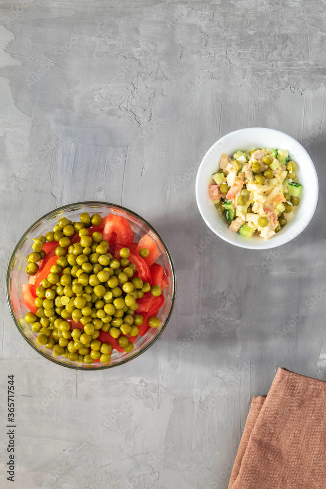 Two summer salads of fresh vegetables in plates on a gray background Two summer salads of fresh vegetables in plates on a gray background