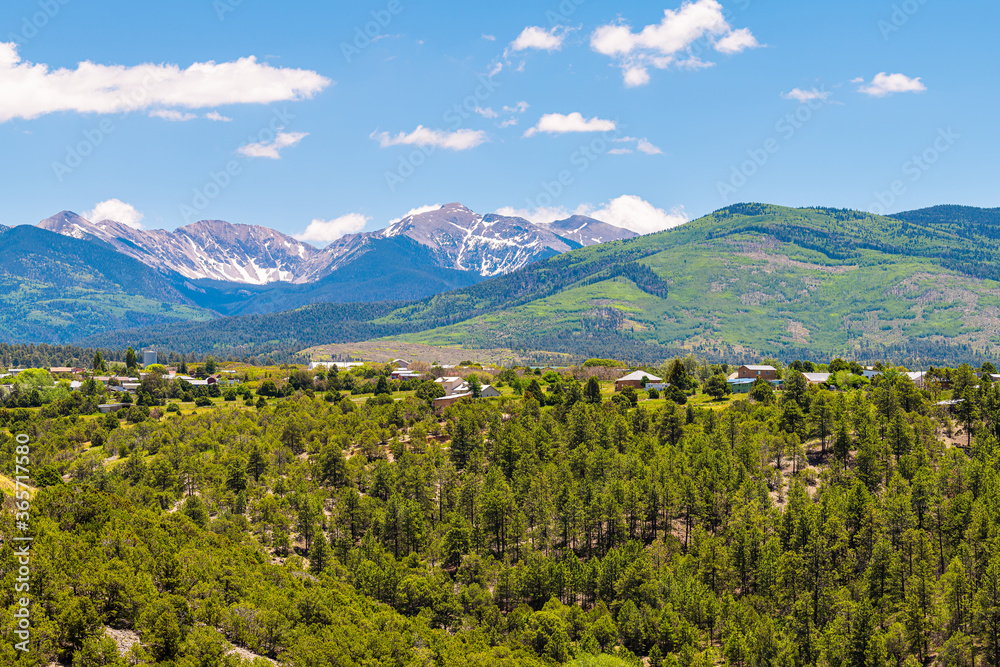 Fototapeta premium Krajobrazowy panoramiczny widok na miasto pod wysokim kątem latem z High Road do Taos gór i wioski Truchas w Nowym Meksyku, USA
