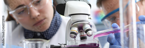 People look at reaction liquid under microscope. Analytical data comparable at inter-laboratory level. Virus under microscope. Laboratory confirmation product quality. Detection poison in liquid.