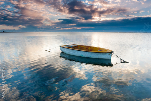 barco en la bahia del fangar en el dela del ebro, con un cielo nublado photo