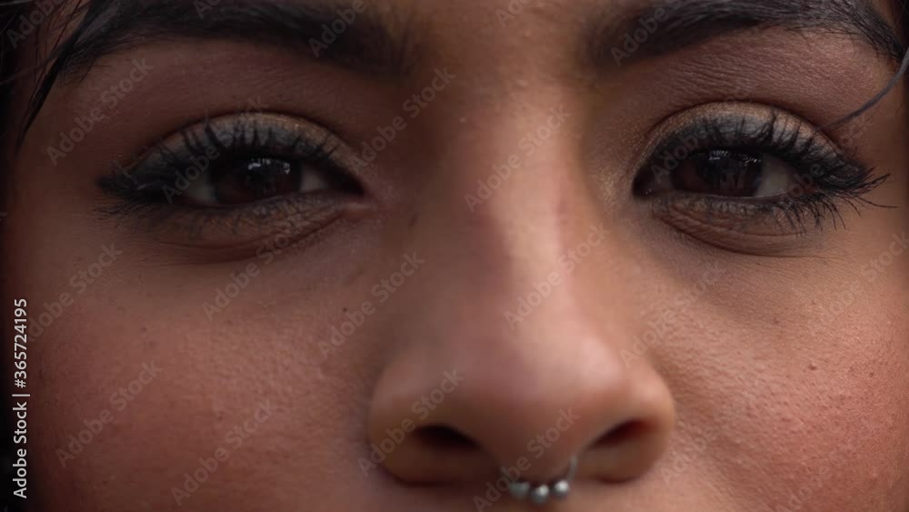 Close-up de ojos con mirada de mujer joven de piel morena mirando fijamente a la cámara. Primer plano de mirada.