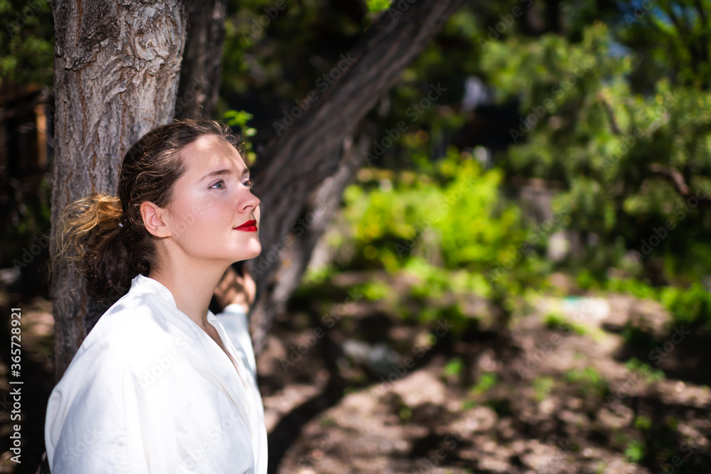 Young woman portrait closeup in yukata white spa bathrobe robe in outdoor garden in Japan with nature view Young woman portrait closeup in yukata white spa bathrobe robe in outdoor garden in Japan with nature view