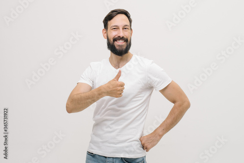Cute young man smiles, shows his fingers like.