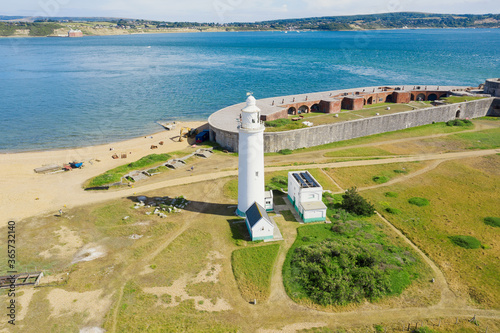 Aerial view of Hurst point, in the United Kingdom. Lighthouse by the sea with the castle in the background by the sea.  photo