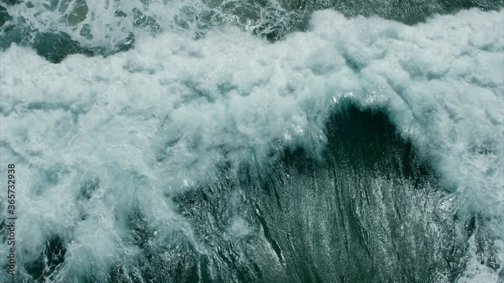 Vitality of blue energy and clear ocean water. Powerful stormy sea waves in top-down drone shot perspective.  Crashing wave line in Open Atlantic sea with foamy white texture.