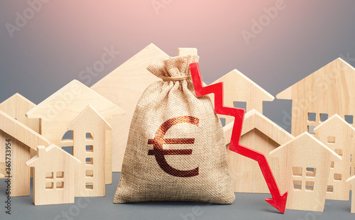 City residential buildings and euro money bag with a red down arrow. Falling prices for rental apartments. Lower mortgage interest rates. Low cost of real estate. Reducing demand for home buying