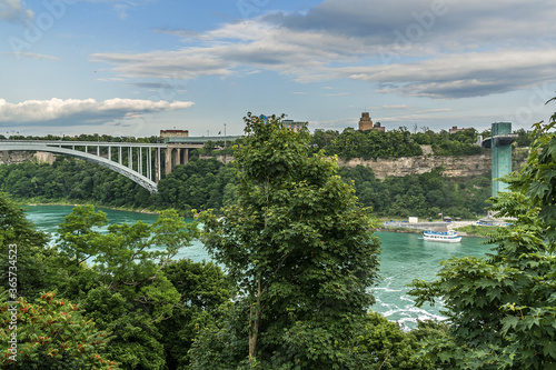 "Rainbow Bridge" at Niagara Falls - international steel arch bridge across Niagara River, world-famous tourist site. Bridge connects cities of Niagara Falls, New York (USA) and Niagara Falls (Canada).