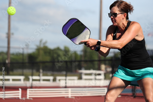 Slika na platnu A two handed backhand is hit during a pickleball match