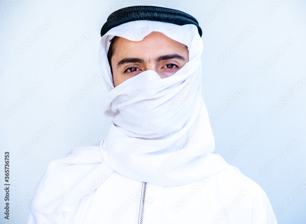 Arabic young man masking his face with hatta Arabic young man masking his face with hatta