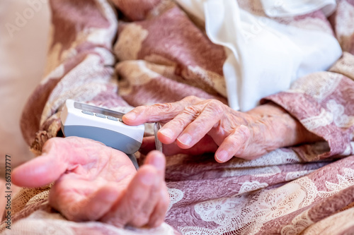 Arabic old woman check her blood pressure using electronic press