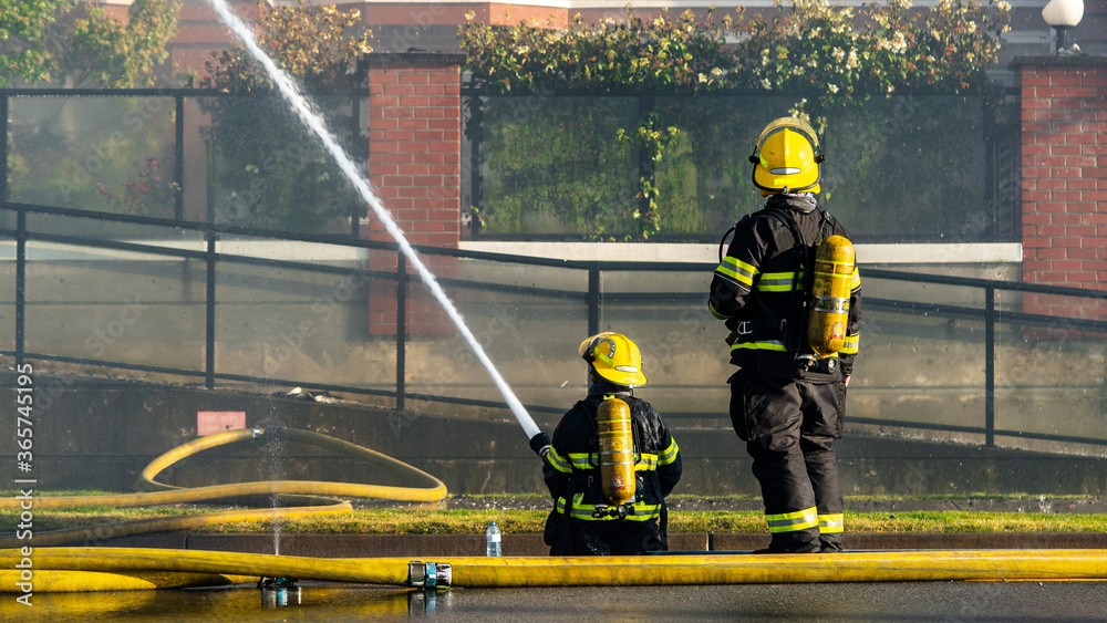 Firefighters trying to put out a fire at a residential building. A risky job only the brave. Essential workers at their duty.  