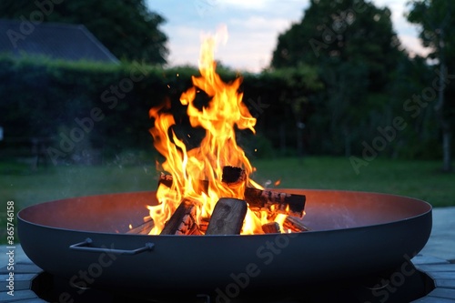 Iron fire pit and burning fire in a garden .  Campfire ,  close up image . photo