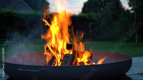 Iron fire pit and burning fire in a garden .  Campfire ,  close up image .