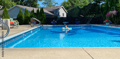 swimming pool woman floating relaxing meditating looking into sun