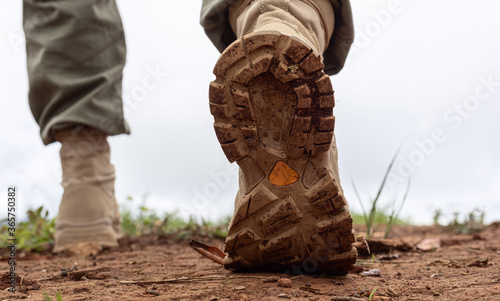 Close-up of male hiker shoes walking on a mountain trail.