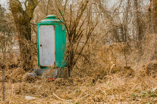 Green portable toilet with dirty white door