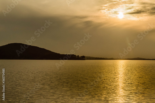 Sunset over lake on cloudy evening.