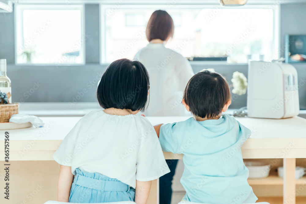 家の中で子供二人が並んで母親の背中を見ている 朝食 食卓 シングルマザー Stock Foto Adobe Stock