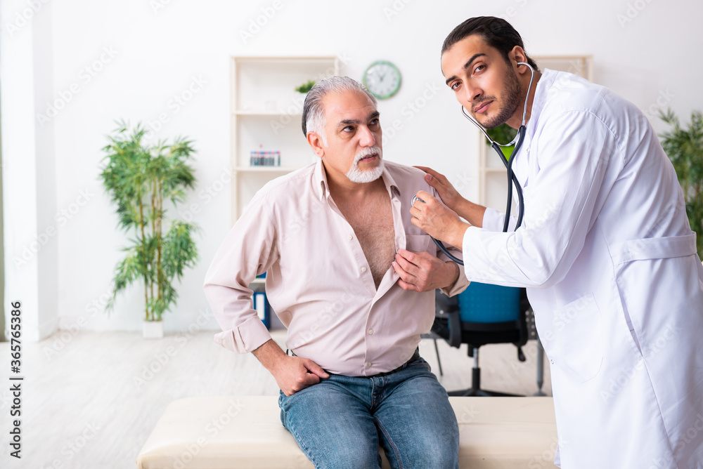 Fototapeta premium Old man visiting young male doctor cardiologist