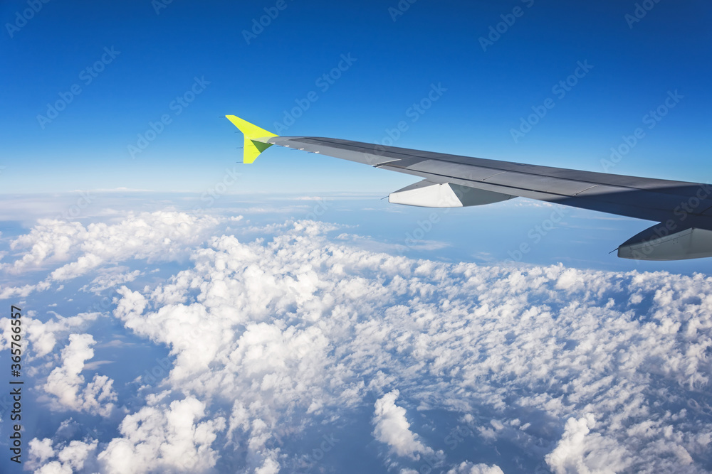 View from the side of the plane on the wing and cumulus clouds on a summer day while traveling. View from the side of the plane on the wing and cumulus clouds on a summer day while traveling.