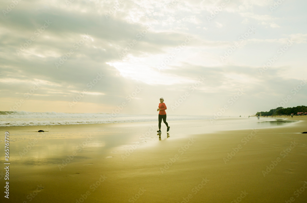 Silhouette of middle aged woman running on the beach - 40s or 50s attractive mature lady doing jogging workout enjoying fitness and healthy lifestyle at beautiful sea sunset Silhouette of middle aged woman running on the beach - 40s or 50s attractive mature lady doing jogging workout enjoying fitness and healthy lifestyle at beautiful sea sunset