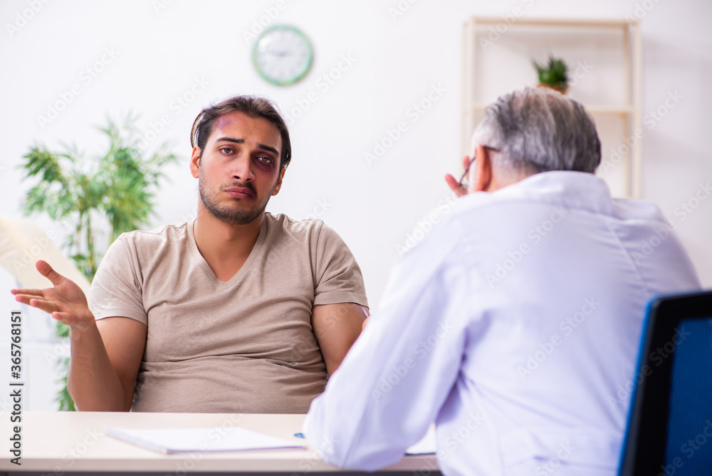 Obraz premium Young face injured man visiting experienced male doctor traumato