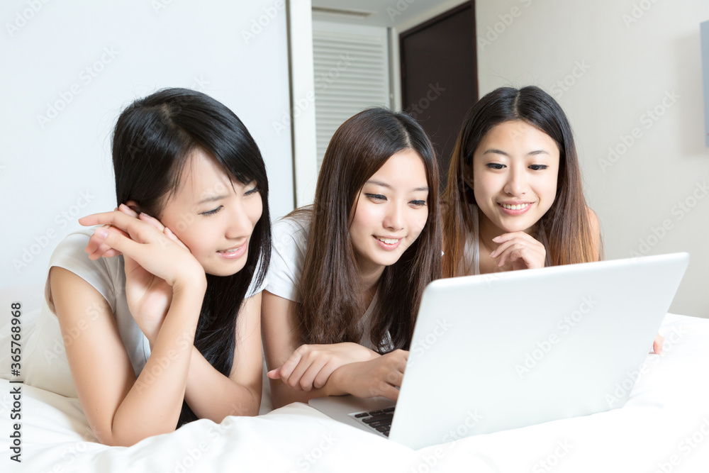 Pretty young girls using laptop in bedroom Pretty young girls using laptop in bedroom