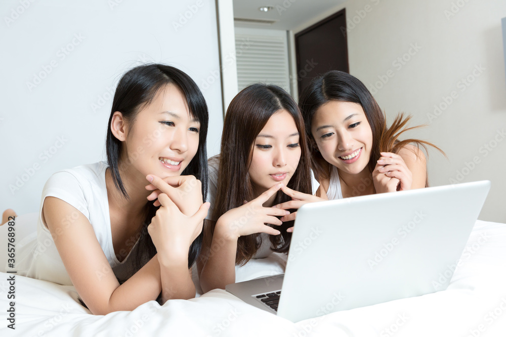 Pretty young girls using laptop in bedroom Pretty young girls using laptop in bedroom