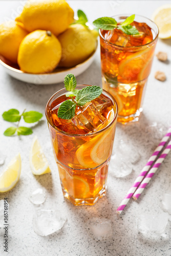Iced tea with lemon, mint and ice cubes. Iced cold summer drink. 