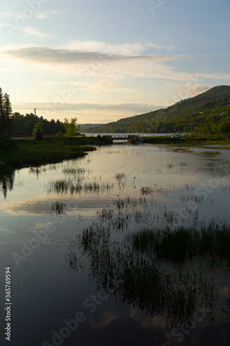 reflected lake with marshland and mountain profile at far end 