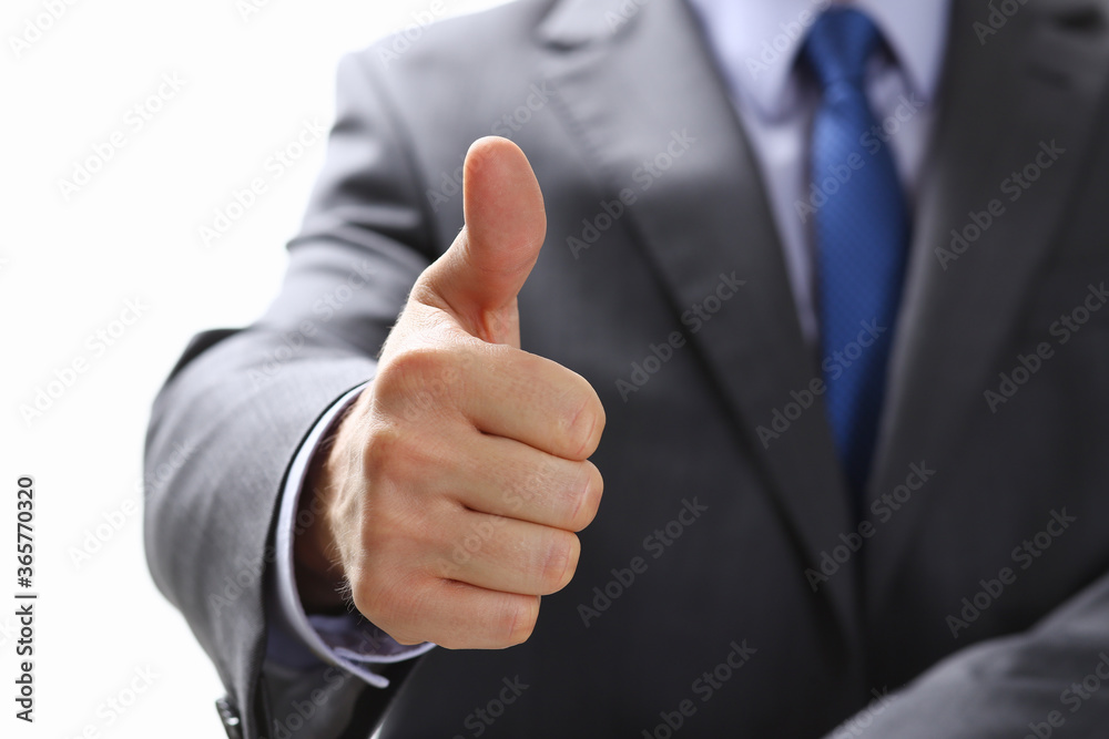 Male hand showing OK or confirm sign with thumb up during conference closeup. High level and quality product, serious offer, mediation solution, happy client, creative adviser participation concept Male hand showing OK or confirm sign with thumb up during conference closeup. High level and quality product, serious offer, mediation solution, happy client, creative adviser participation concept
