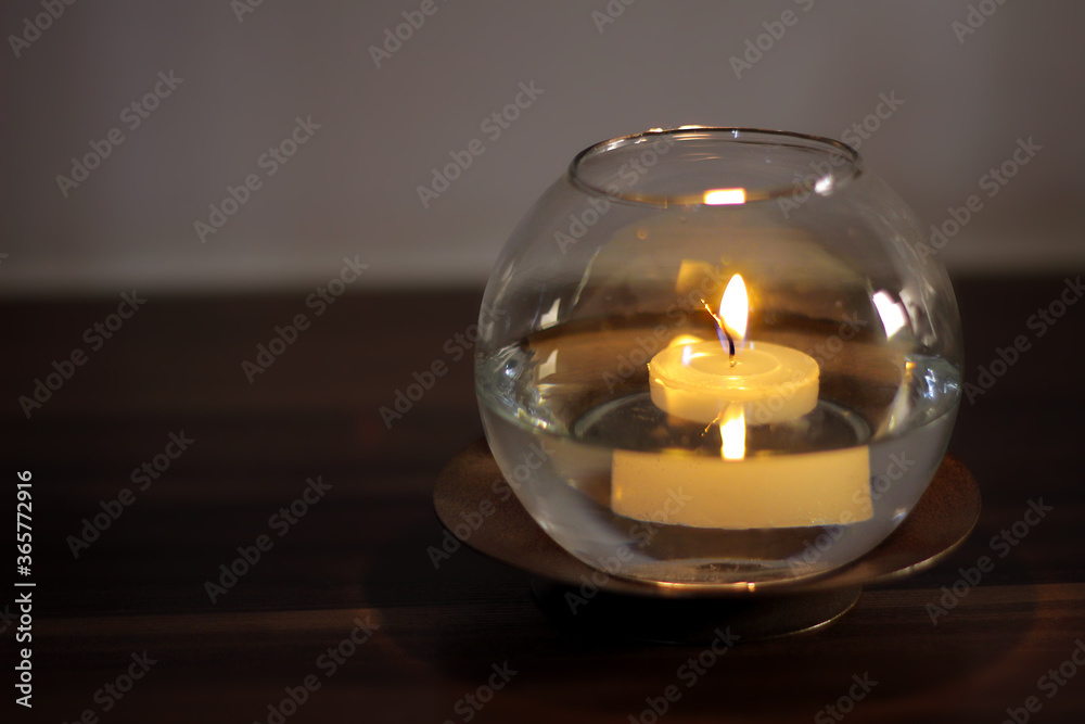 Aromatic candle floating on water in transparent vase Aromatic candle floating on water in transparent vase