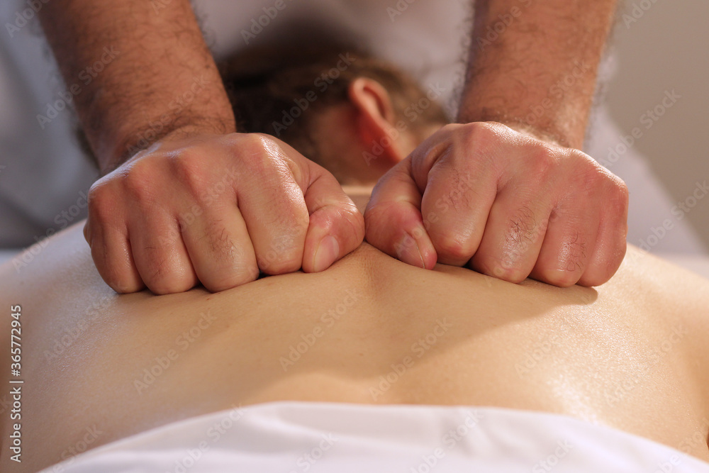 Fototapeta premium Close up of hands with closed fist massaging female back