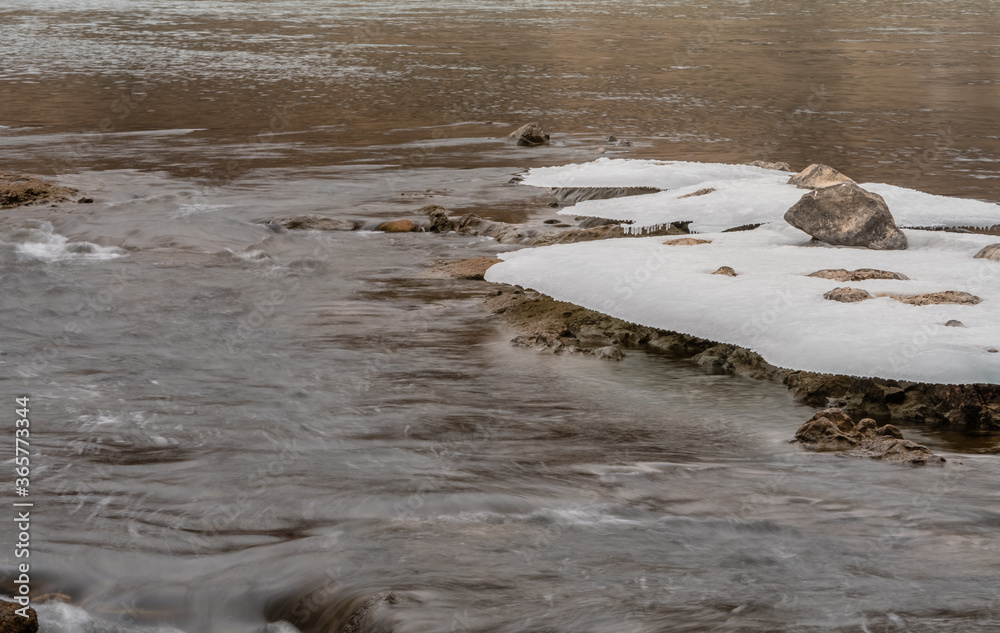 Sheets of ice frozen to large boulders Sheets of ice frozen to large boulders