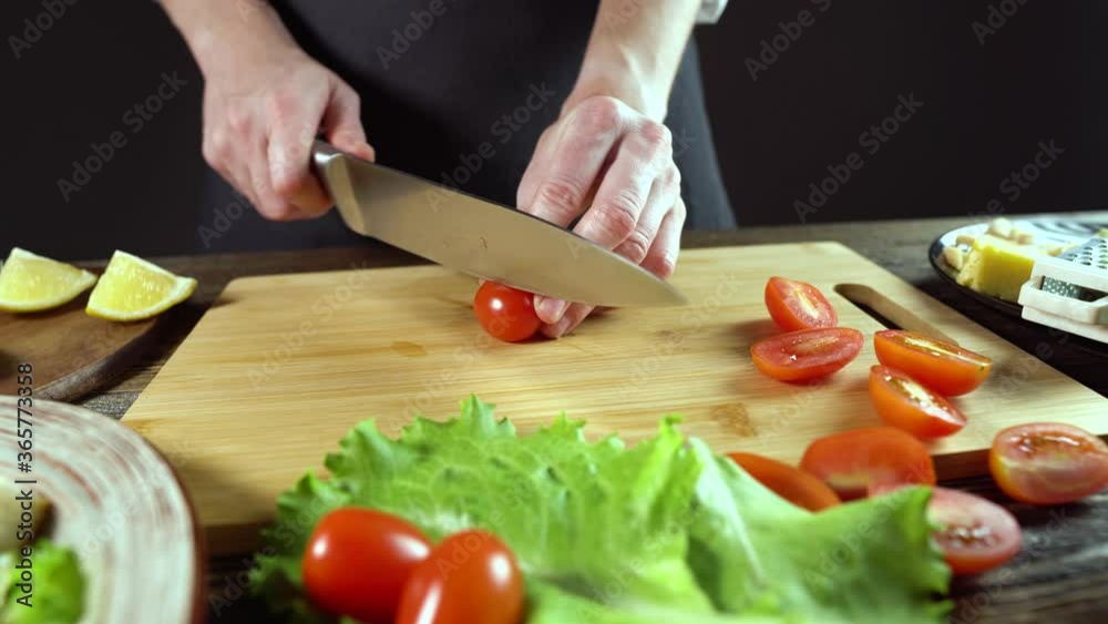 Chef is cutting the tomatoes. Concept of the process of preparing a fresh delicious dish Chef is cutting the tomatoes. Concept of the process of preparing a fresh delicious dish