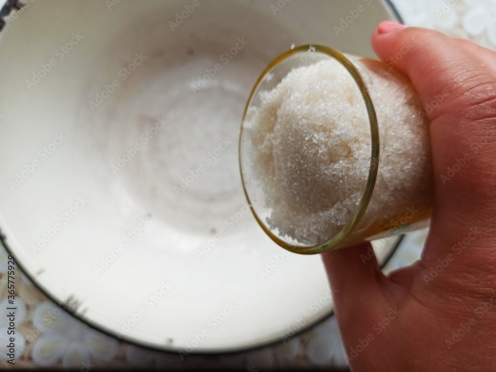 woman throw sugar to bowl on table