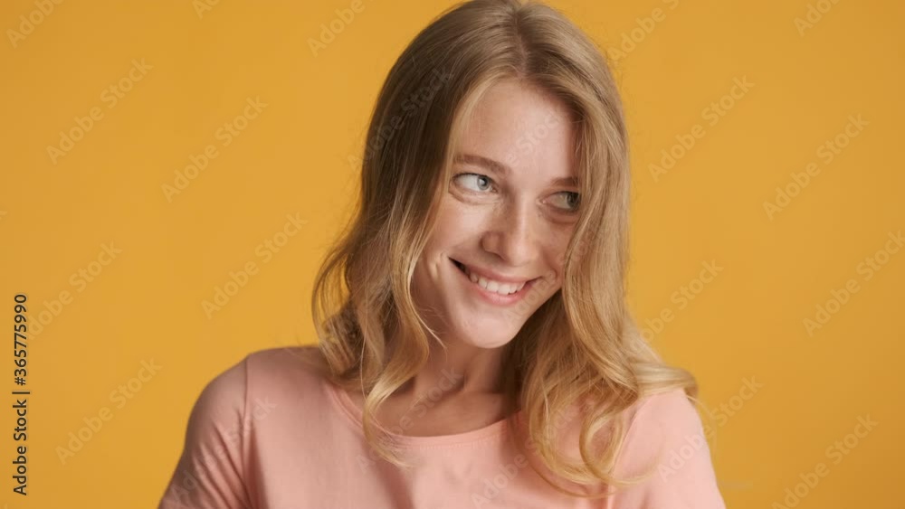 Beautiful flirty girl charmingly looking in camera over colorful background. Flirting on camera Beautiful flirty girl charmingly looking in camera over colorful background. Flirting on camera