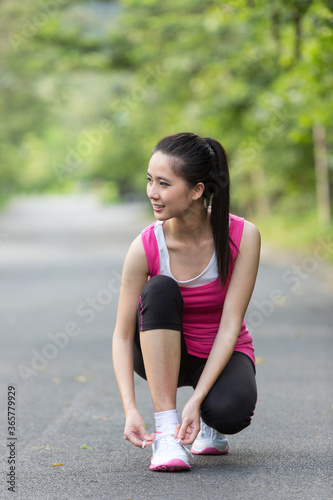 Young Asian woman doing exercise outdoors