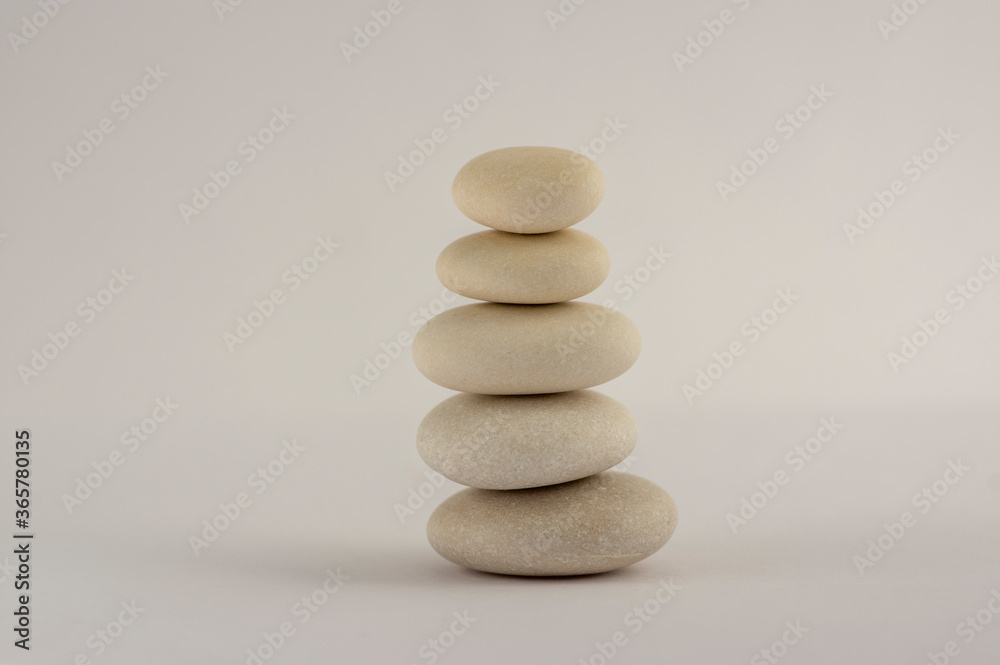 One simplicity stones cairn isolated on white background, group of five white pebbles in tower One simplicity stones cairn isolated on white background, group of five white pebbles in tower