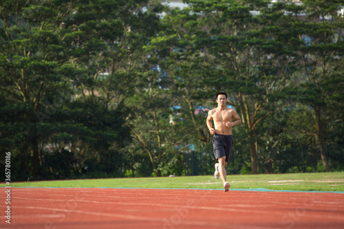Young Asian man doing exercise outdoors © JodieWang