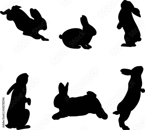 Set of hand-drawn running, looking up and sitting in various poses rabbits black silhouette . Set of Easter bunny outlines isolated on white background. Simple cartoon bunny.