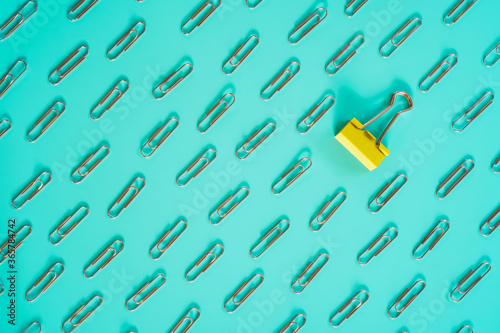 Slika na platnu yellow clip laid among pattern of silver paper clip on mint color background , d