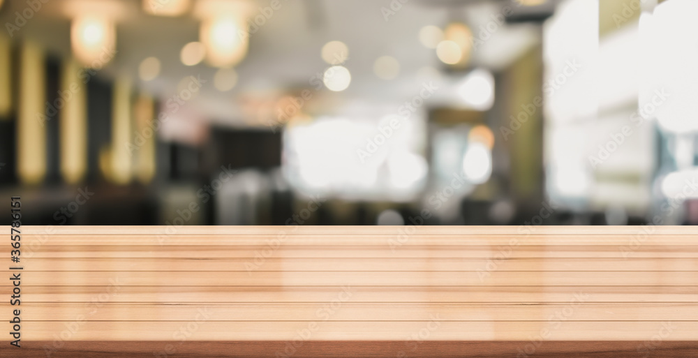 Empty wooden table top with lights bokeh on blur restaurant background