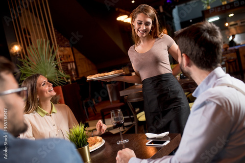 Waiter woman serving group ...