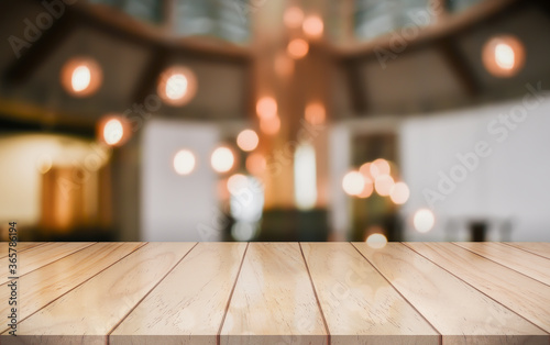 Empty wooden table top with lights bokeh on blur restaurant background © DEEP PIXEL